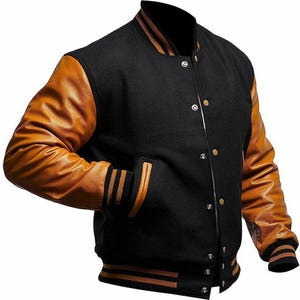 Puede incluir: Chaqueta universitaria negra con mangas de cuero marrón claro. La chaqueta presenta un cuerpo negro, mangas marrones claras y detalles a rayas en el cuello, los puños y el dobladillo. Tiene cierre de botones y dos bolsillos delanteros.
