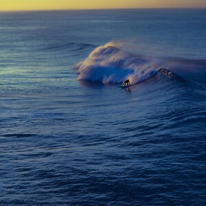 Lone Rider - Surfer at Sunset on Powerful Blue Break