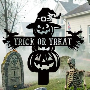 May include: Black metal Halloween garden stake with a jack-o'-lantern design, a witch's hat, and the words "TRICK OR TREAT". The stake has bat and branch accents, ideal for outdoor Halloween decorations.