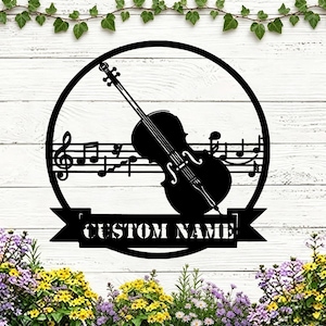May include: Black metal wall art featuring a cello silhouette, musical notes, and the text "CUSTOM NAME" within a circular frame. The design is set against a white wooden background, with floral accents.