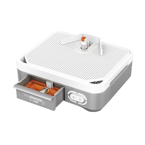 May include: A gray and white glass grinder with a perforated top and a pull-out drawer. The drawer is labeled "THE GRINDER 2" and contains accessories. The grinder has a white handle and two illuminated buttons on the front.