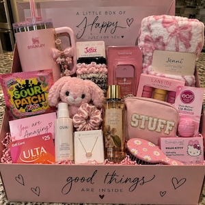 May include: A pink gift box containing a Stanley tumbler, a Jenni throw blanket, Sour Patch Kids, a plush bunny, Justice scrunchies, a Touchland mist, Laneige lip masks, an Eos lip balm, a Ouai conditioner, a Victoria's Secret spray, a Kendra Scott necklace, a pouch, a hairbrush, and Hello Kitty eye patches.