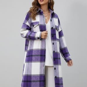 Peut inclure: Un long manteau à carreaux boutonné, dans une palette de couleurs violet, blanc et noir. Le manteau présente un col, deux poches avant et une fente sur l'ourlet. Il est porté sur un haut et un pantalon blancs.