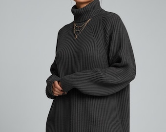 Op de afbeelding: Een donkergrijze coltrui-jurk van ribgebreide stof. De jurk heeft een relaxte pasvorm, lange mouwen en een hoge halslijn. Het model draagt gouden sieraden. De jurk is gemaakt van een dik, warm materiaal, ideaal voor koeler weer.