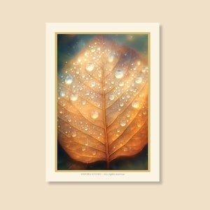 May include: A close-up of a leaf with water droplets. The leaf is a warm, golden-brown color with visible veins. The water droplets are clear and reflect light, creating a sparkling effect. The image is framed with a cream-colored border.