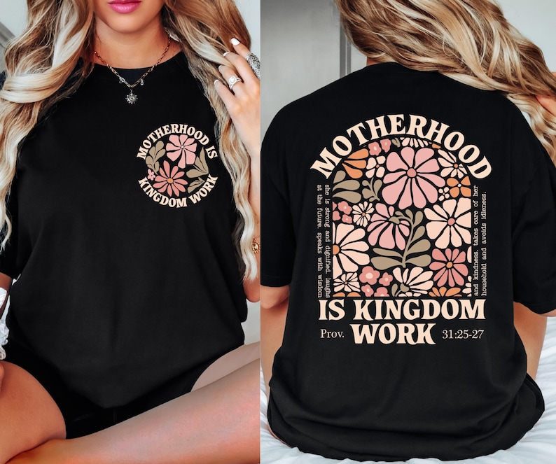 May include: Black t-shirt with the text "MOTHERHOOD IS KINGDOM WORK" in a floral design. The front of the shirt has a smaller version of the design. The back of the shirt features a larger floral design with the same text and Bible verse.