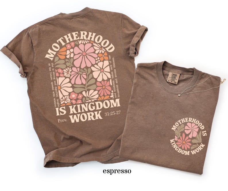May include: Two espresso-coloured t-shirts. One features a floral design and the text "MOTHERHOOD IS KINGDOM WORK" on the back, with additional text from Proverbs 31:25-27. The other shirt has the same design on the front.