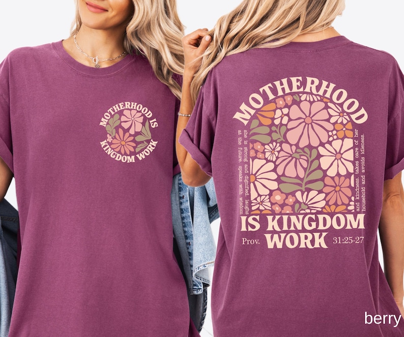 May include: Berry-coloured t-shirt with the text "Motherhood is Kingdom Work" and a floral design on the front and back. The back of the shirt features a larger floral design and the Bible verse Proverbs 31:25-27.