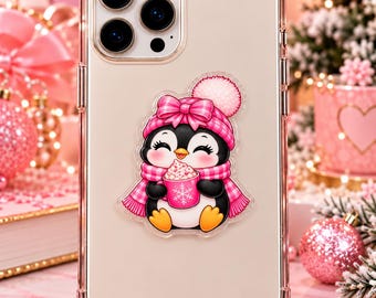 May include: A clear smartphone case featuring a central graphic of a black and white penguin wearing a pink plaid winter hat with a pom-pom and a matching scarf. The penguin holds a pink mug decorated with a white snowflake and filled with foam.