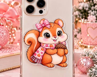 May include: A clear smartphone case featuring a cartoon squirrel illustration. The squirrel has orange fur, a pink polka-dot bow, and a pink scarf with pumpkin and leaf patterns. It holds a brown acorn in its paws. The case has a triple-lens camera.