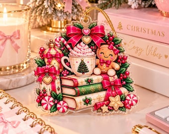 May include: A clear acrylic Christmas ornament featuring a gingerbread person, a mug of hot cocoa with whipped cream, stacked books, and wrapped gifts, all decorated with red bows, green holly, and candy canes, suspended by a gold cord.