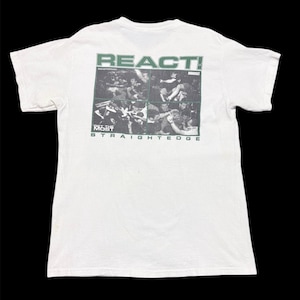 Pode incluir: Camiseta branca com um gráfico verde nas costas. O gráfico inclui a palavra "REACT!" acima de uma colagem de imagens em preto e branco. Abaixo da colagem, as palavras "GET THE MOST STRAIGHTEDGE" são impressas em verde.