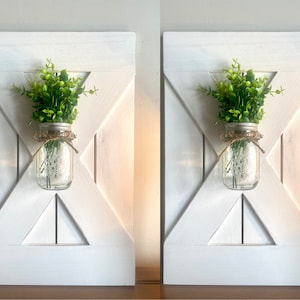 Peut inclure: Deux d&eacute;corations murales de style farmhouse en bois blanc avec un bocal en verre rempli de verdure suspendu au centre de chaque pi&egrave;ce.