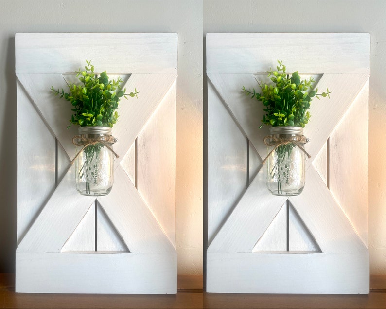 Peut inclure: Deux d&eacute;corations murales de style farmhouse en bois blanc avec un bocal en verre rempli de verdure suspendu au centre de chaque pi&egrave;ce.