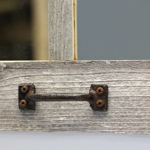 May include: A rustic wooden frame with a grey wash finish. The frame has a metal handle with two screws on each side.