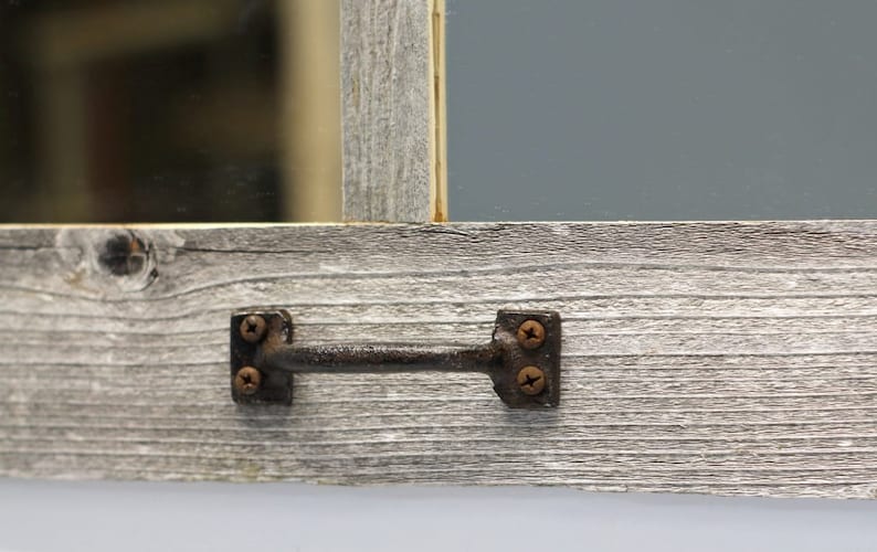 May include: A rustic wooden frame with a grey wash finish. The frame has a metal handle with two screws on each side.