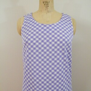 May include: A sleeveless dress with a white and purple gingham pattern.