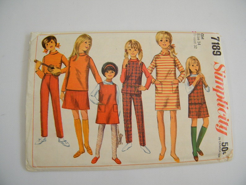May include: Simplicity sewing pattern number 7189 for girls sizes 14 and 12. The pattern includes five different outfits, including a plaid jumper, a striped dress, and a red skirt with a matching sweater.