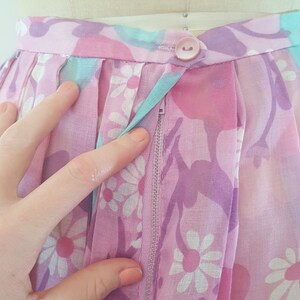 May include: A pink and purple floral skirt with a zipper closure and a single button at the waist.