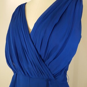 Puede incluir: Un vestido maxi sin mangas azul real con escote en V y falda fluida.