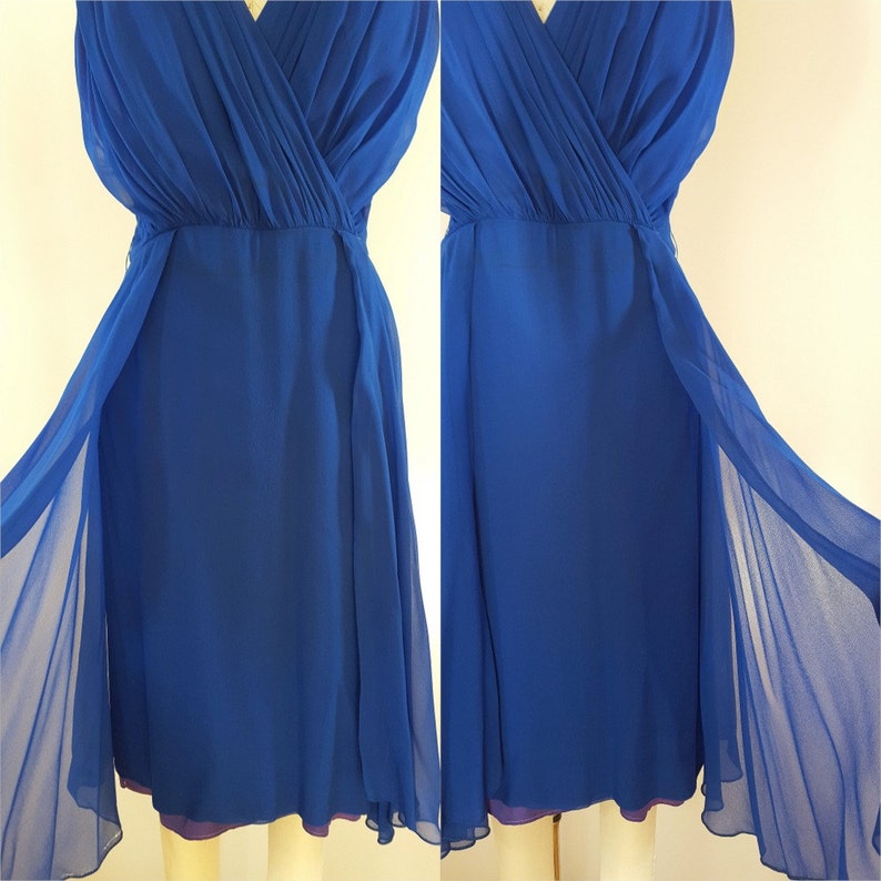 Puede incluir: Un vestido de gasa azul real con escote en V y falda fluida. El vestido tiene un corpi&ntilde;o estilo envolvente y una superposici&oacute;n transparente.