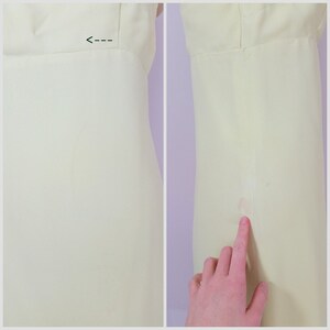 Puede incluir: Un vestido amarillo p&aacute;lido con una costura en el lateral. El vestido tiene una ligera mancha en la costura lateral.