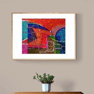 Peut inclure: Impression d'art abstrait dans un cadre en bois. L'œuvre présente un design géométrique coloré avec des formes rouges, oranges, bleues et vertes. L'impression est affichée au-dessus d'une commode en bois avec une petite plante en pot.