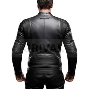 May include: Black leather jacket with ribbed detailing on the shoulders and sleeves. The jacket has a stand-up collar and a zipper closure. The back of the jacket features horizontal and vertical ribbed accents. The jacket is part of a leather outfit.