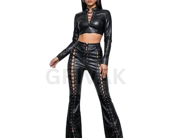 May include: Black faux leather crop top with long sleeves and a lace-up front. Matching black faux leather pants with lace-up detailing along the sides. The pants have a flared leg design. The outfit is a two-piece set.