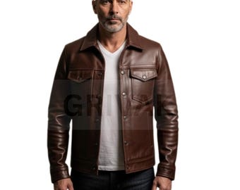 May include: A brown leather jacket with a button-up front, two chest pockets, and a collared neckline. The jacket is worn over a white V-neck shirt and dark blue jeans. The image features the word "GR" in the lower left corner.