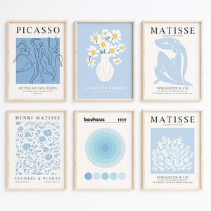 Puede incluir: Seis impresiones artísticas enmarcadas con artistas y diseños famosos. Las impresiones incluyen estilos Picasso, Matisse y Bauhaus. La paleta de colores es principalmente azul claro y blanco, con texto en negro. Las impresiones están en marcos de madera.