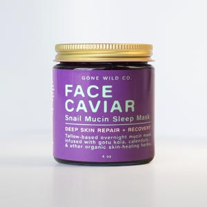 Puede incluir: Un tarro de Face Caviar Snail Mucin Sleep Mask de Gone Wild Co. El tarro tiene una tapa dorada y una etiqueta morada con texto blanco. La etiqueta dice "Face Caviar" y "Snail Mucin Sleep Mask". El tarro contiene 118 ml de producto.