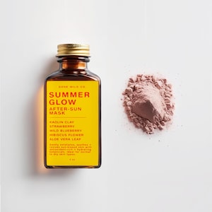 Könnte beinhalten: Eine braune Glasflasche mit goldenem Deckel und gelbem Etikett mit der Aufschrift "SUMMER GLOW AFTER-SUN MASK". Daneben ein Haufen rosa Pulver. Das Etikett listet Inhaltsstoffe wie Kaolin-Ton und Erdbeere auf.