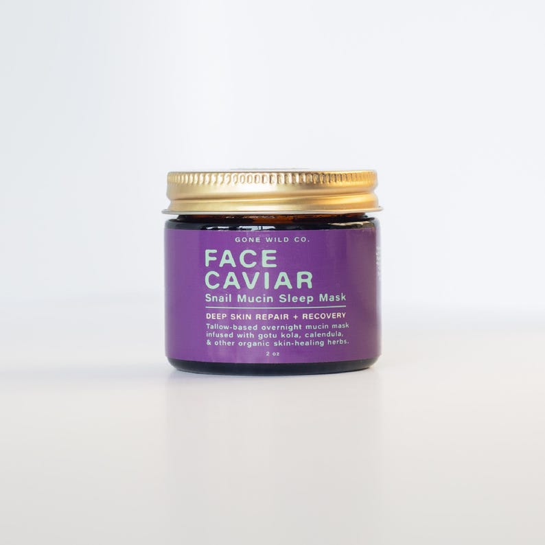 Może przedstawiać: Mały słoiczek Face Caviar Snail Mucin Sleep Mask. Słoiczek ma złotą pokrywkę i fioletową etykietę z białym tekstem. Etykieta zawiera nazwę marki, nazwę produktu i szczeg&oacute;ły produktu. Słoiczek ma 59 ml.