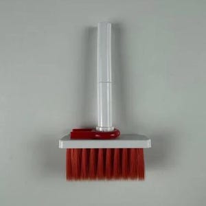 May include: A small, handheld cleaning brush with a white handle and a rectangular head. The brush head features vibrant red bristles. A red plastic piece connects the handle to the brush head.
