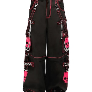 May include: Black wide-leg pants with red stitching and accents. Features include pink skull graphics, chains, and studded details. The pants have multiple pockets and a drawstring waist, creating a bold, alternative style.
