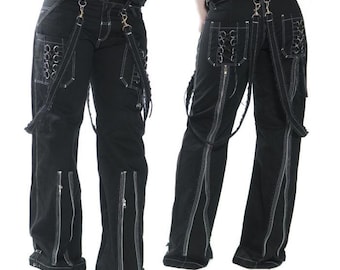 May include: Black pants with white stitching and multiple zippers. The pants have suspenders and decorative metal rings. The design includes pockets and zippers along the legs, creating a unique, edgy style.