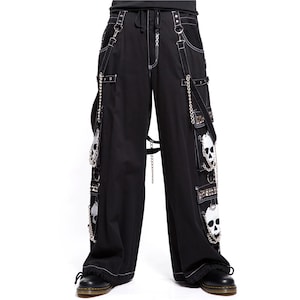 May include: Black wide-leg pants with white stitching, chains, and skull accents. Features multiple pockets, straps, and a drawstring waist. The pants have a gothic or punk aesthetic.