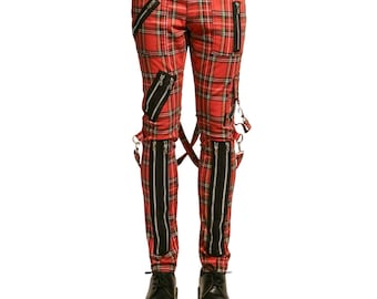 May include: Red plaid pants with multiple black zippers and suspender straps. The pants have a classic tartan pattern and are paired with black boots. The zippers run vertically along the legs and diagonally across the thighs.