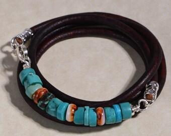 May include: A brown leather wrap bracelet with a silver clasp and turquoise and orange beads.