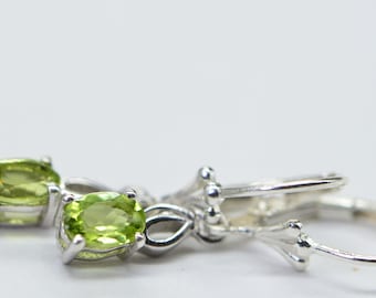Puede incluir: Un par de pendientes de plata con piedras preciosas ovaladas verdes. Los pendientes tienen un diseño sencillo y son perfectos para el uso diario.