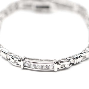 May include: A silver bracelet with a row of clear cubic zirconia stones.