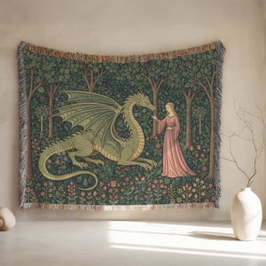 May include: A tapestry depicting a green dragon and a woman in a pink dress in a forest setting. The tapestry has a fringed edge and is displayed on a wall. The artwork is reminiscent of medieval art.