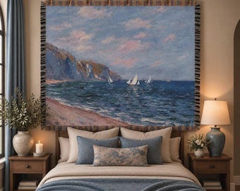 May include: A rectangular woven wall tapestry featuring an impressionist seascape painting of sailboats on a dark blue ocean near rocky cliffs under a pink and blue sky, suspended from a brass rod with a decorative fringe border.