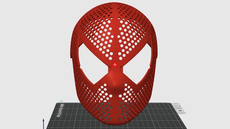May include: A red mask with a web-like pattern of holes, featuring large eye openings and a nose section. The mask's design is reminiscent of a superhero's mask. The mask is likely made of plastic.