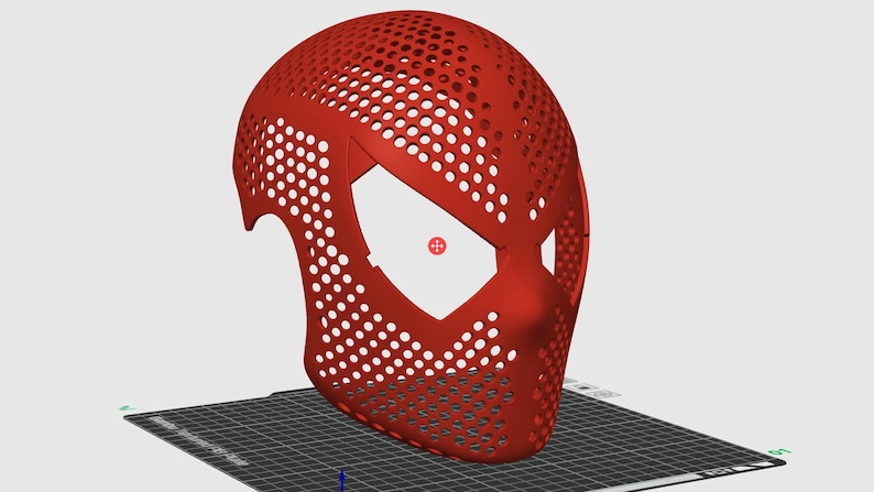 May include: A red, perforated mask with a distinctive eye shape, likely for cosplay or costume use. The mask is 3D-printed, featuring numerous small holes for breathability and a smooth, curved design. It sits on a black and gray surface.