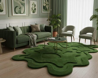 May include: A modern living room with a green theme. A green sofa with pillows, two armchairs, and a coffee table with a marble top. A unique, organic-shaped green rug covers the floor. Artwork and plants complete the decor.