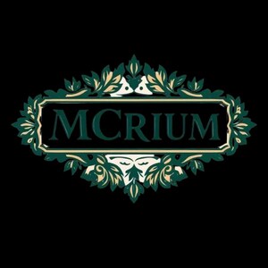 以下が含まれることがあります： 黒い背景に、濃い緑色の「MCRIUM」という文字が入った装飾ロゴ。テキストは長方形の枠で囲まれ、緑とクリーム色の華やかな花と葉のデザインが施されています。