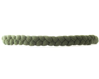 May include: A braided headband in a solid olive green color. The accessory features a continuous, uniform plait design constructed from a soft, fabric-covered material that creates a textured, woven appearance across the entire length of the band.