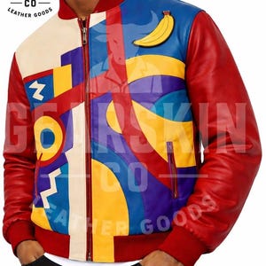 Puede incluir: Chaqueta de cuero colorida con diseño geométrico y parche de plátano. La chaqueta tiene mangas rojas, cuello rojo y cierre de cremallera. El frente presenta un mosaico de formas azules, amarillas y moradas. Se ve el logo de la marca "GEARSKIN CO LEATHER GOODS".